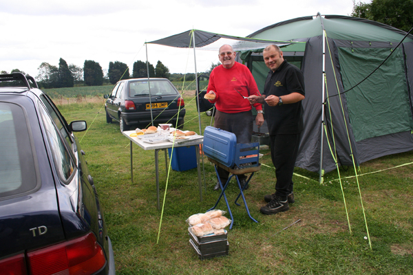 Left Jim M0MAC and right Dave M0TAZ
Dave and Jim keep a careful eye on the BBQ. Jim models the new "high visibility" jumper as used by the fire brigade.
Keywords: red m0mac m0taz