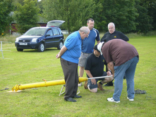 Setting up the mast
Jim M0MAC (far left) looks on, having just finished another packet of crisps
